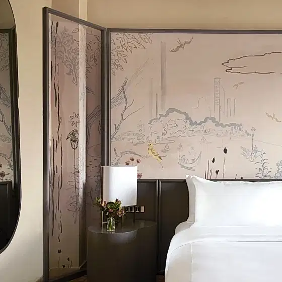park lane room king with a king bed against a beautiful mural. A night stand an mirror on the wall to the left.