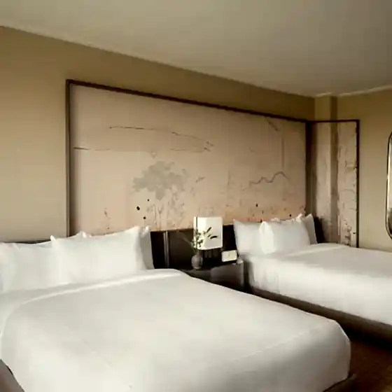 Two queen beds against a hand painted mural at Park Lane New York.