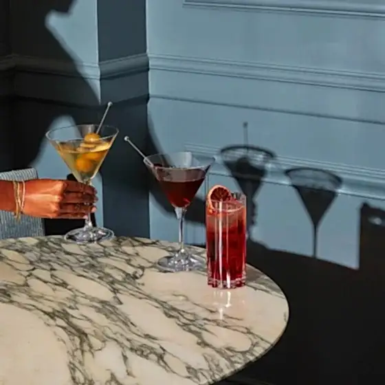 Three assorted cocktails on a marble table.