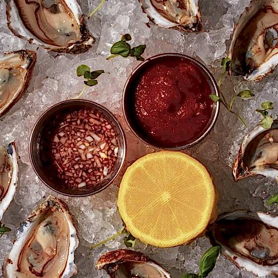 Oysters on ice with mignonette and lemon.