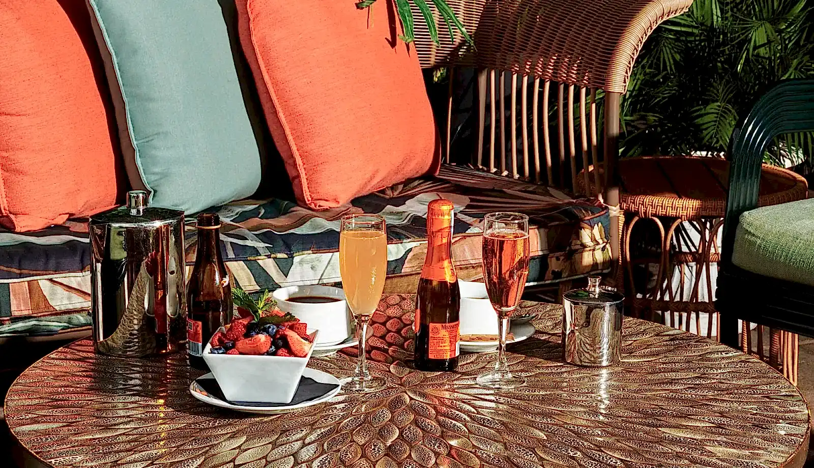 An assortment of drinks and fruit on a warm patio terrace.