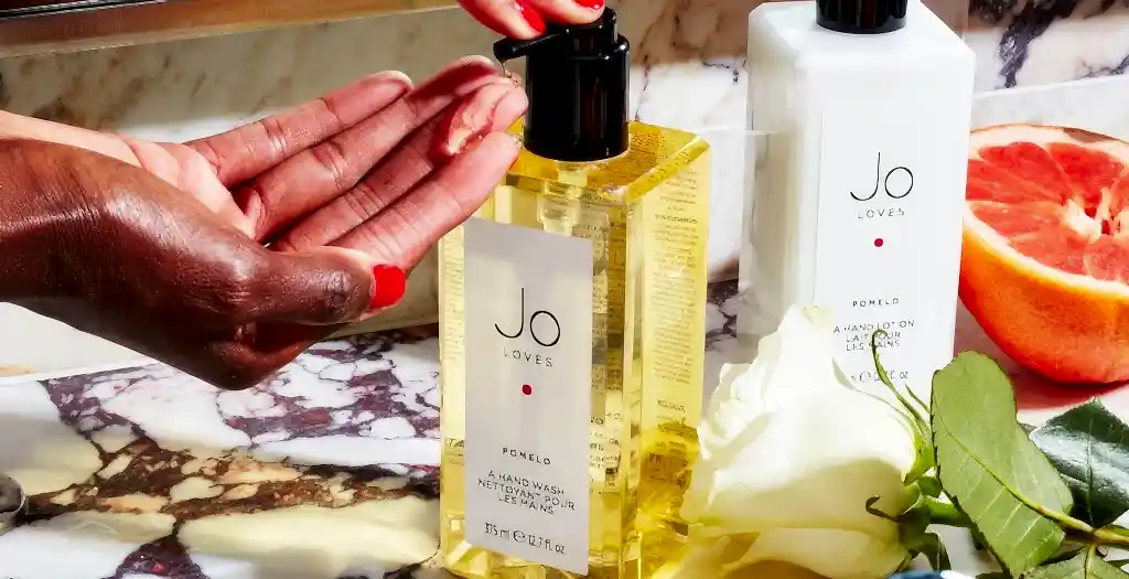 A woman pumps hand wash into her hand.