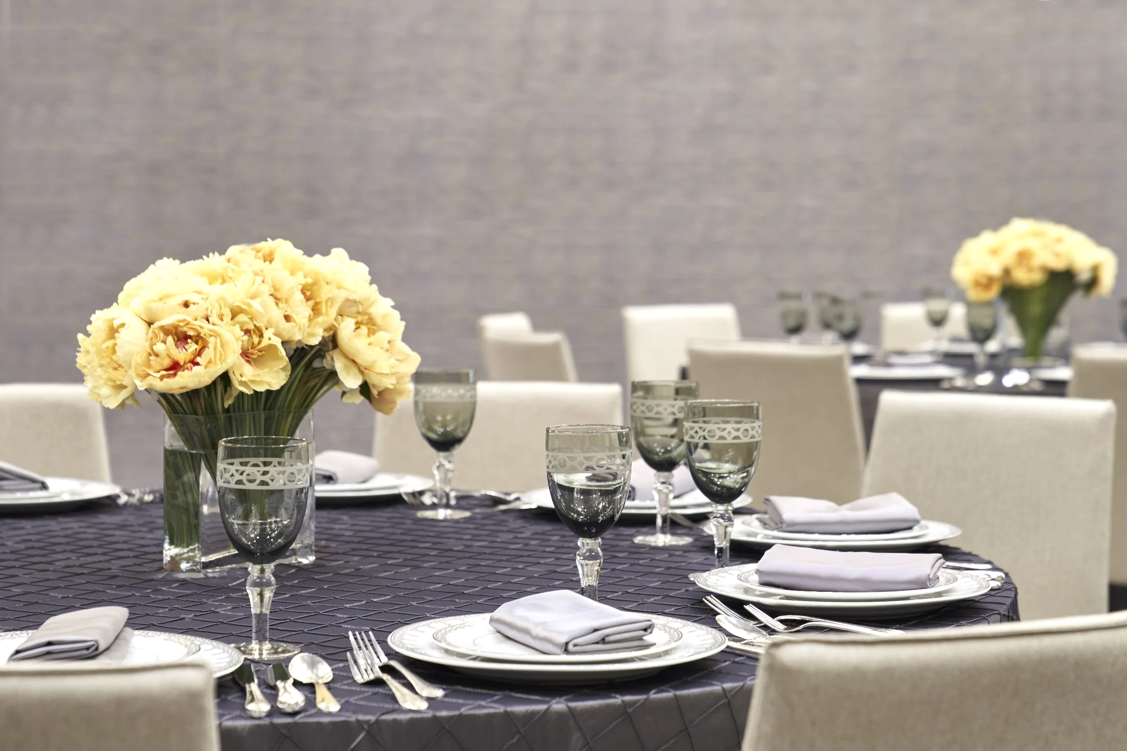 A table set with china, cutlery and glasses for an event.