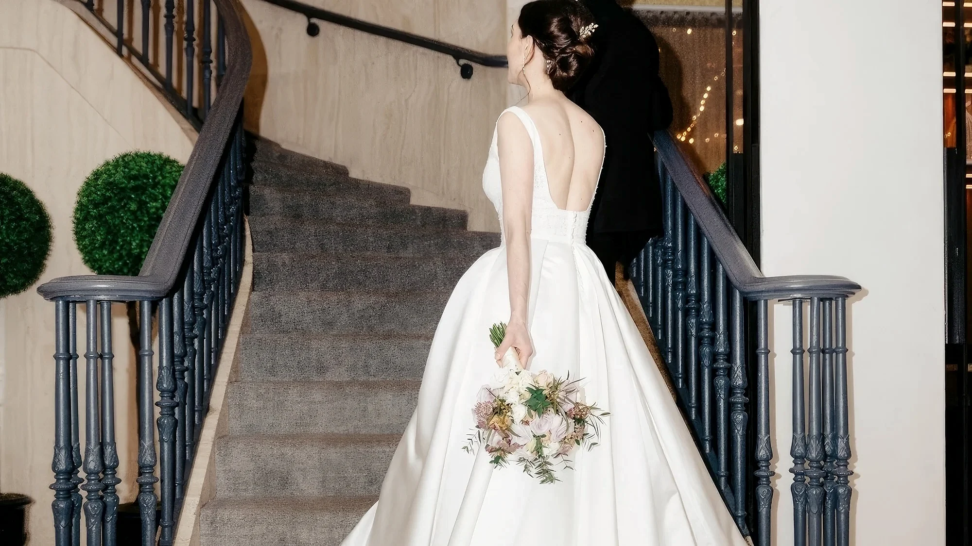 A bride and groom walking up stairs.
