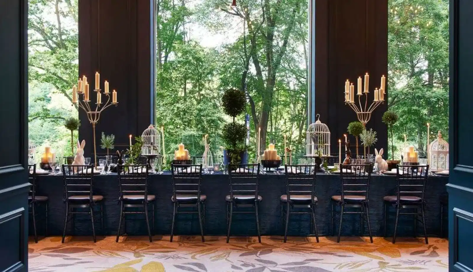 An elegant dining room with views of lush green outside.